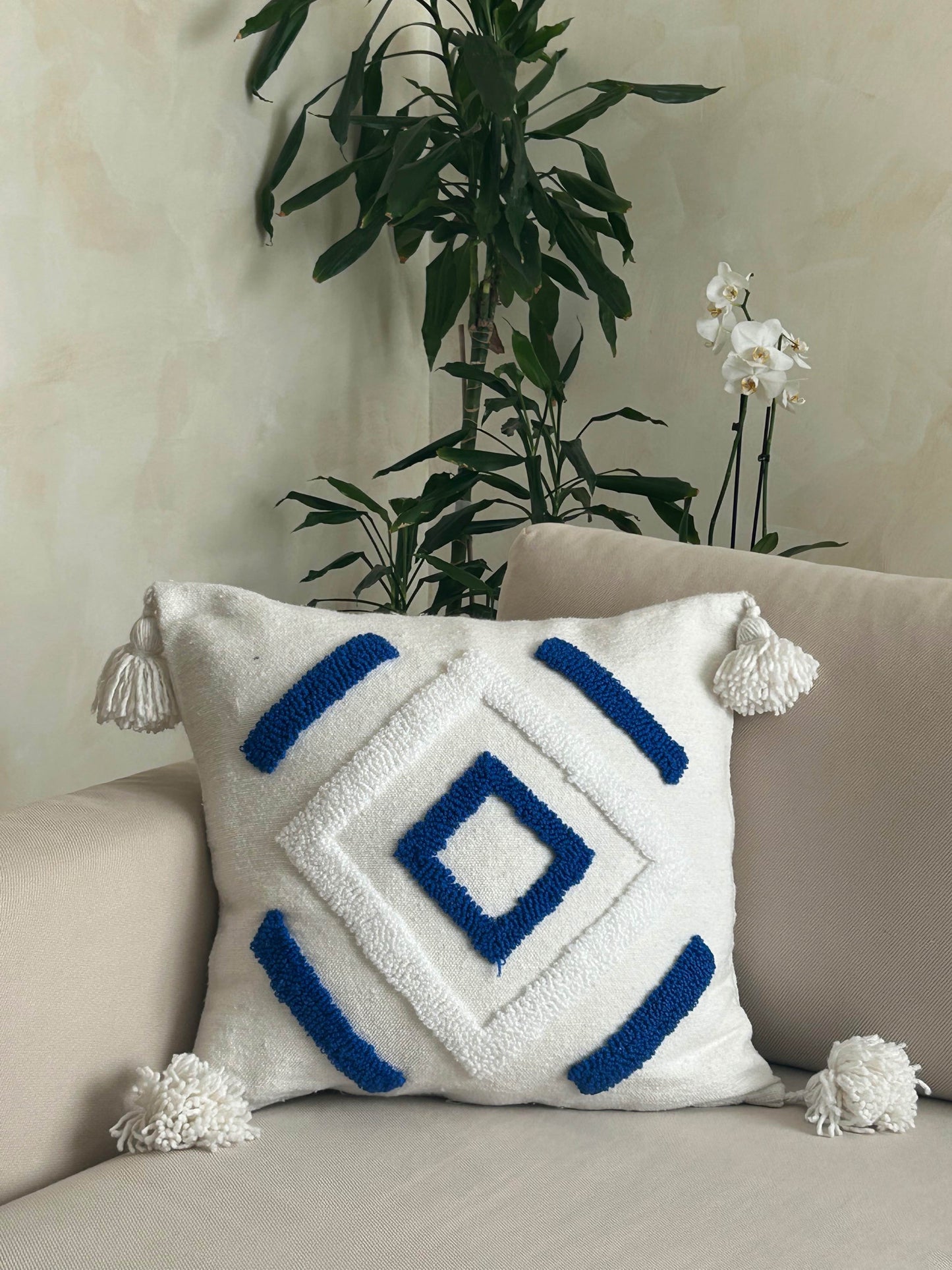 housse de coussin carrée, en laine blanche, et pompons, motifs berbères géométriques blanc et bleu, confection artisanale