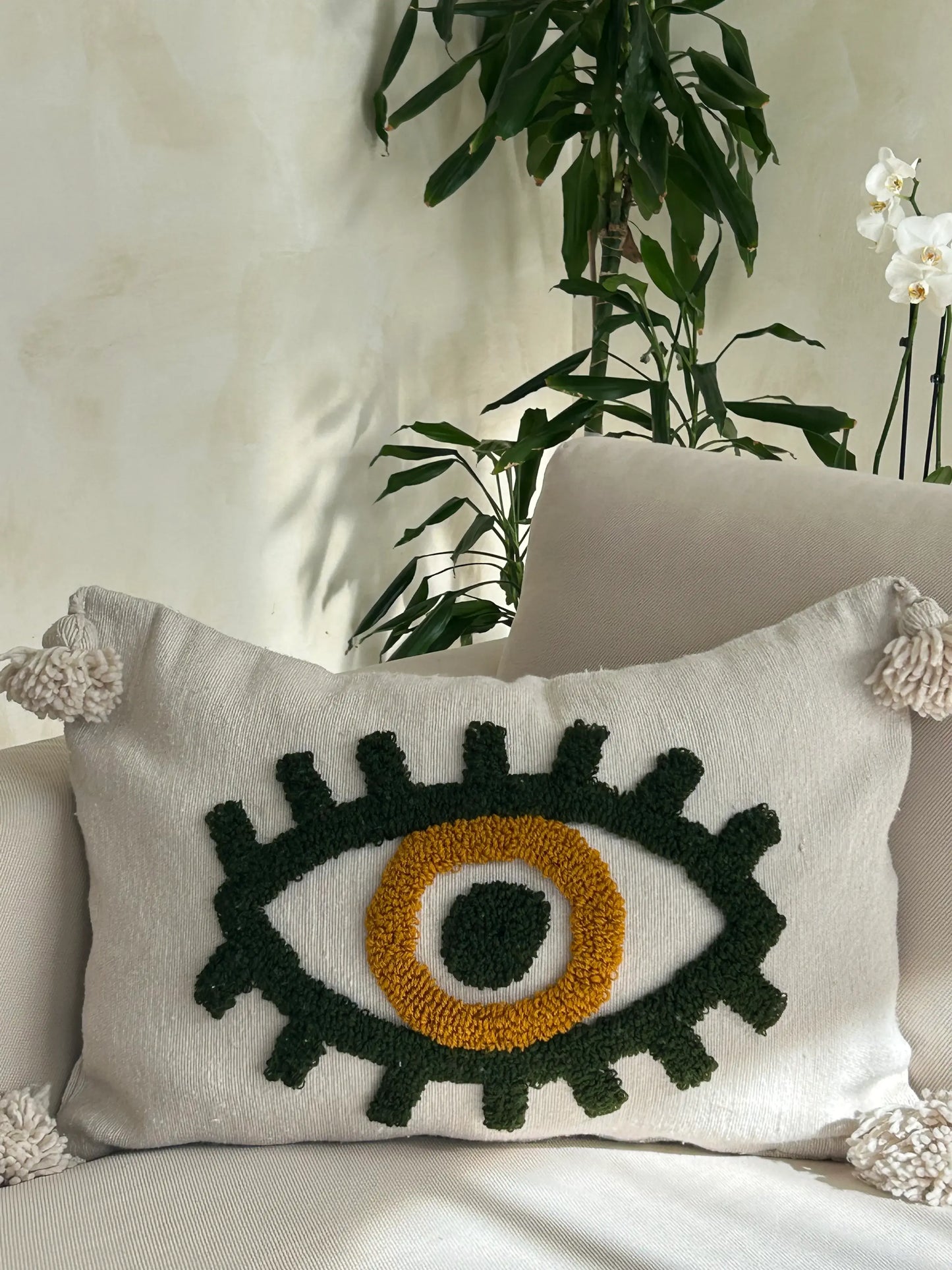 housse de coussin en laine tissée avec un oeil vert au centre, artisanale