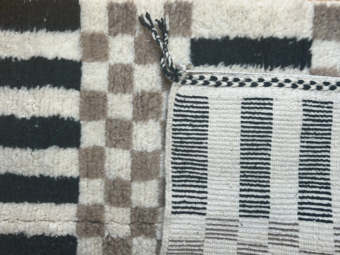 zoom sur les motifs damier et rayure et sur l'arrière du tapis