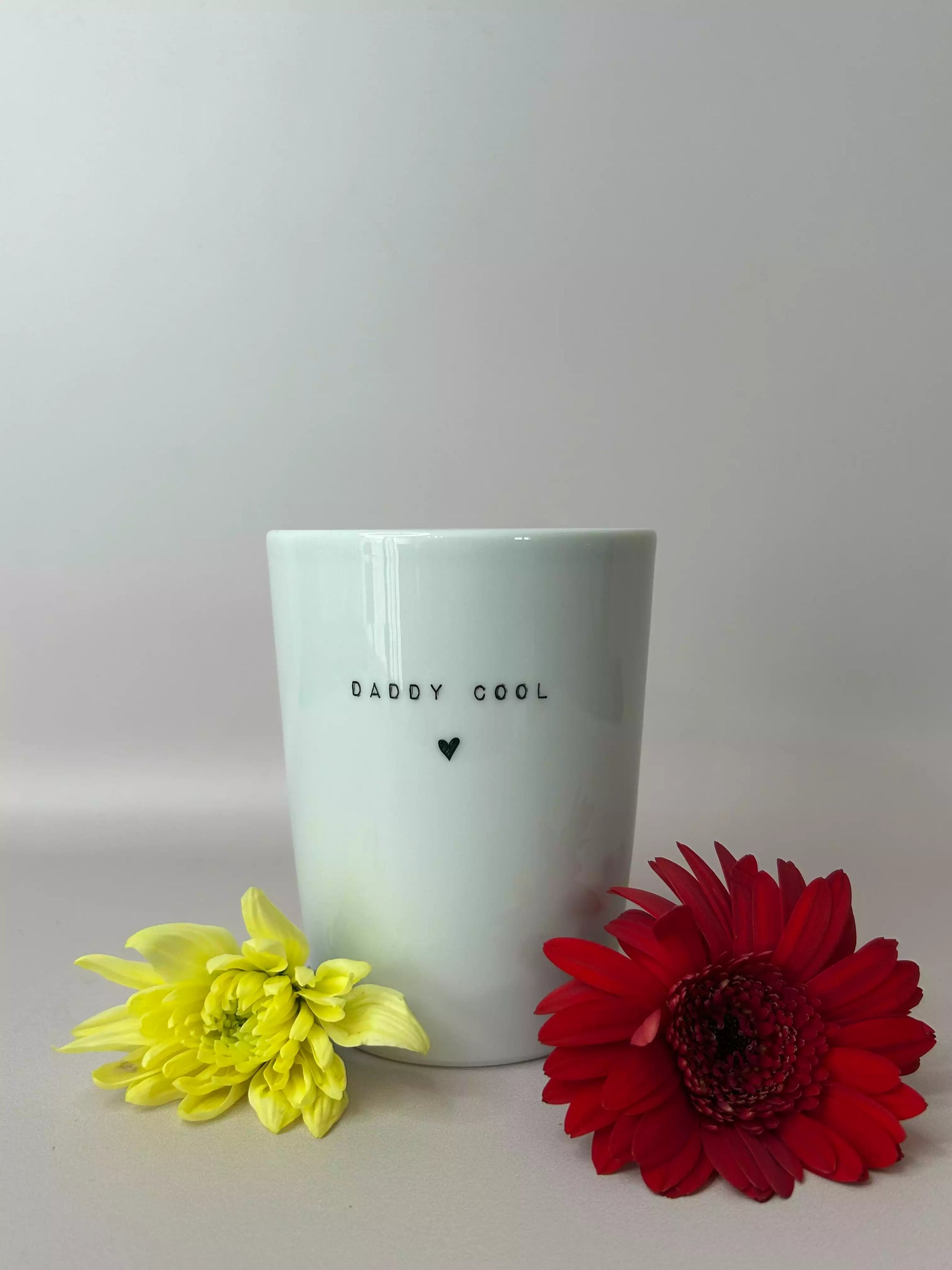 gobelet en porcelaine avec inscription dandy cool accompagné d'une fleur jaune et d'une fleur rouge 