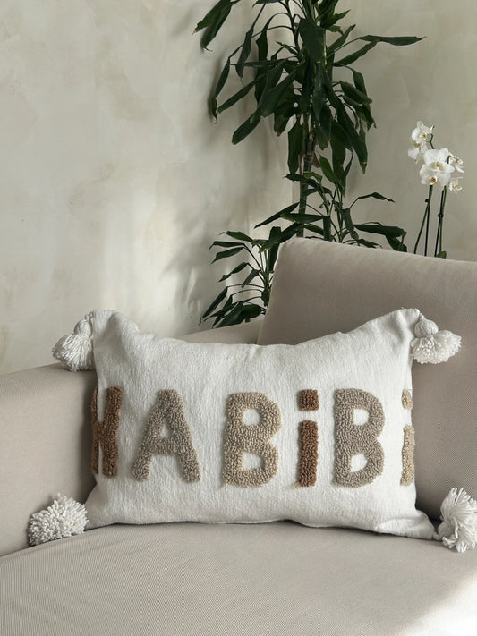Housse de coussin rectangulaire en laine artisanale avec motif brodé Habibi en marron gris et beige et pompons