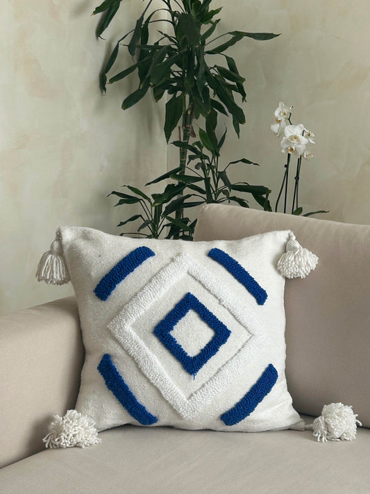 housse de coussin carrée, en laine blanche, et pompons, motifs berbères géométriques blanc et bleu, confection artisanale