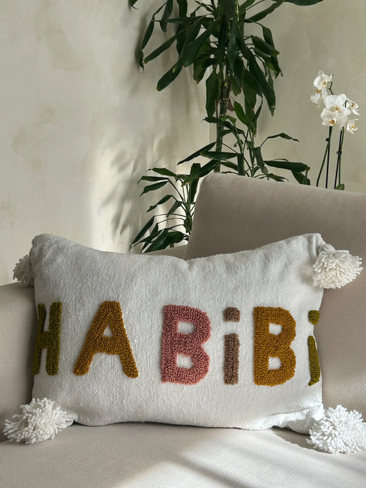 housse de coussin en laine blanche avec pompons et motif Habibi en laine multicolore